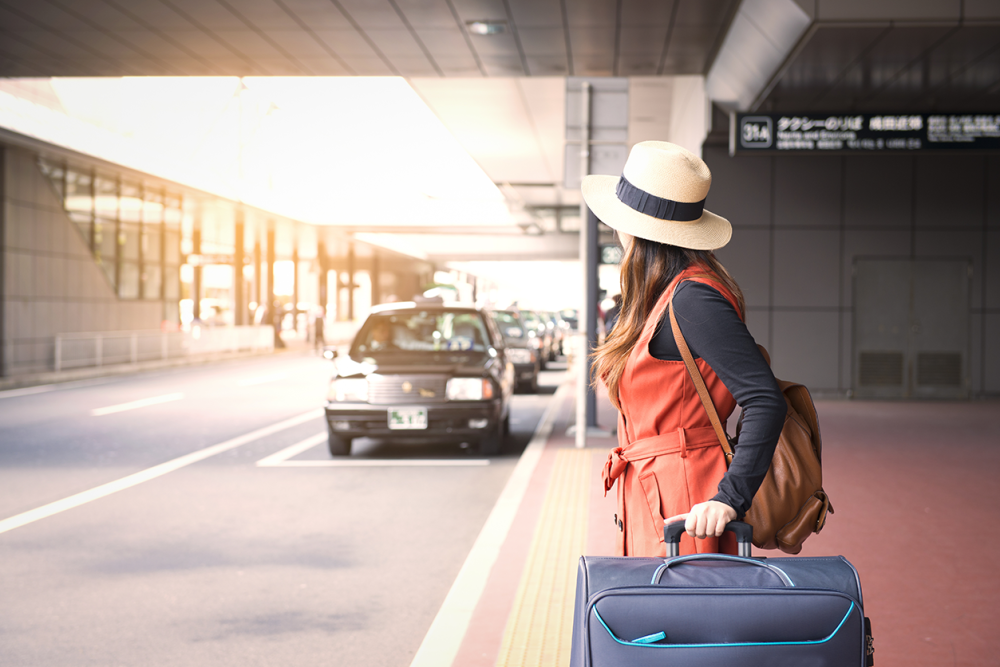 Femme qui attend le taxi à l'aéroport